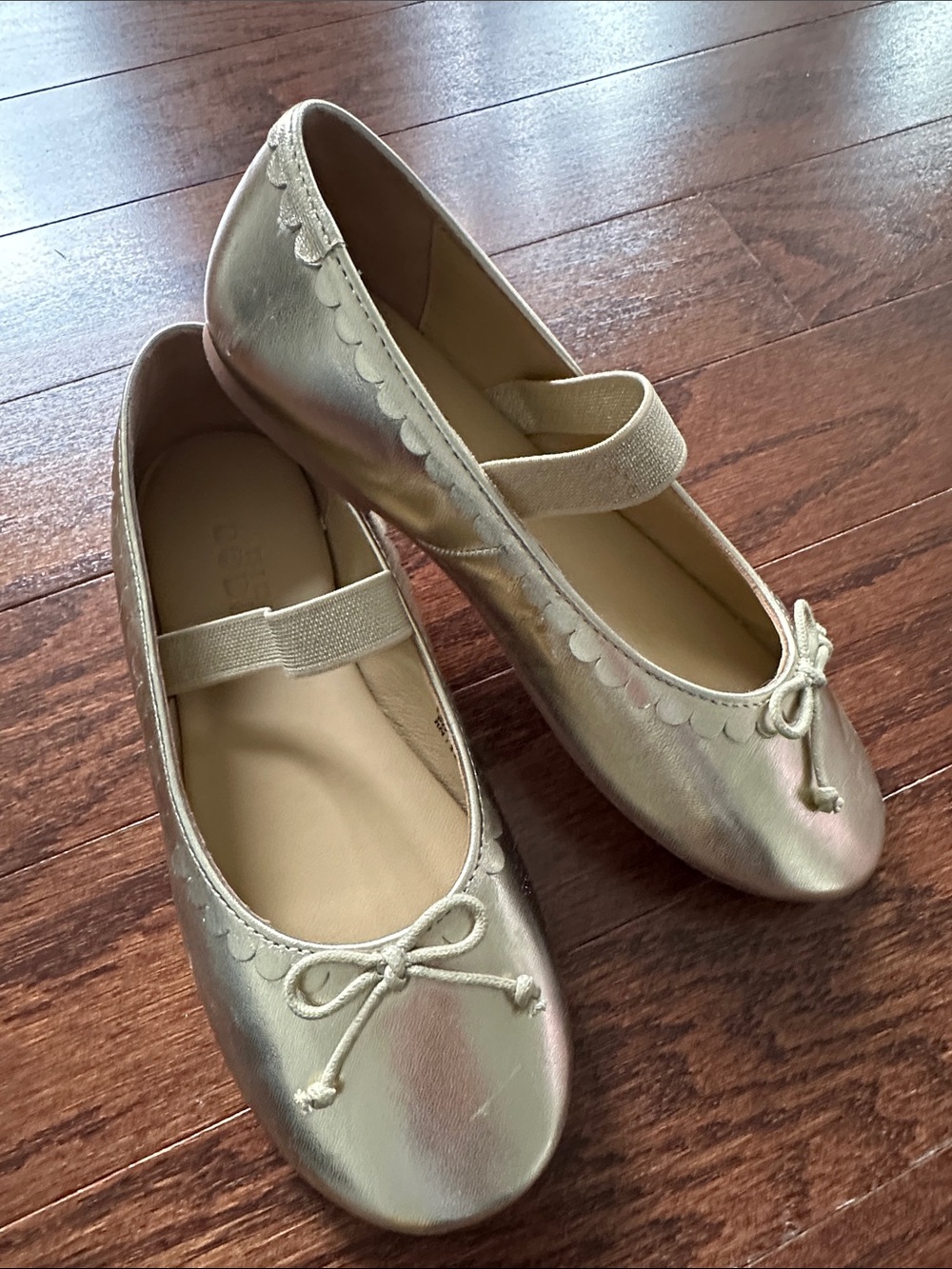 Mini Boden Girls' Gold Ballet Flats with Bow and scalloped trim.